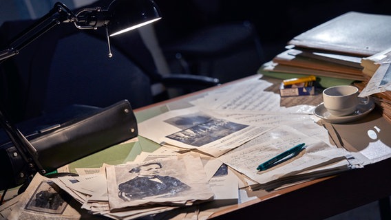 ein Schreibtisch voller Akten, eine Tasse Kaffee und Zigaretten und einem Foto von Tschaikowsky © NDR Foto: Micha Neugebauer
