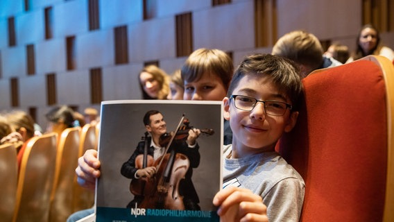 Junge mit einem Programmheft der NDR Radiophilharmonie © NDR Foto: Helge Krückeberg