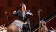 Konzertszene: Eiji Oue dirigiert die NDR Radiophilharmonie © Screenshot Foto: NDR