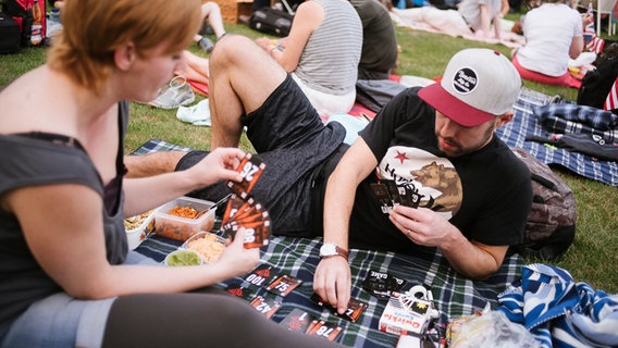 Besucher von "Hannover Proms" spielen vor Beginn der Veranstaltung Karten. © NDR Foto: Julius Matuschik