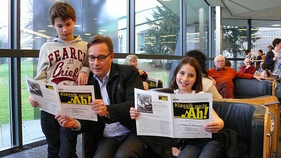 Familie liest Konzertprogrammheft. © NDR Radiophilharmonie Foto: Corinna Lüke