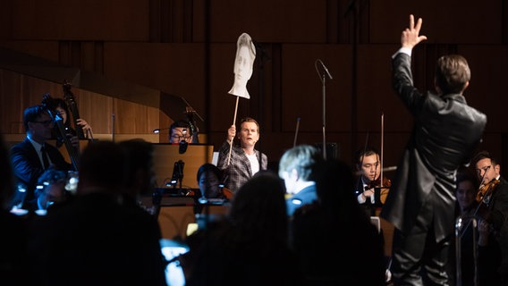 Malte Arkona, Moderator im Orchester-Detektive-Konzert, Dirigent Cornelius Meister und die NDR Radiophilharmonie © NDR Foto: Helge Krückeberg