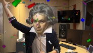 Malte Arkona hält sich eine Beethoven-Maske vor das Gesicht. Drumherum fliegt Konfetti. © NDR Radiophilharmonie 