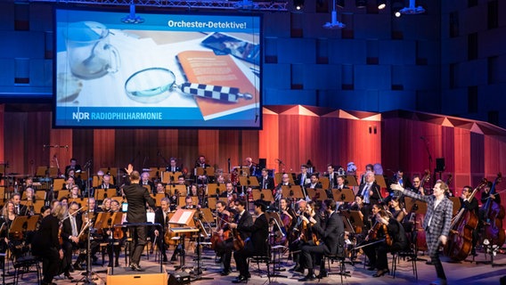 Die NDR Radiophilharmonie vor Projektion auf Leinwand im Großen Sendesaal Hannover beim Konzert der Orchester-Detektive © NDR Foto: Helge Krückeberg