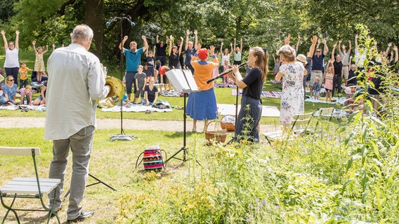 Tanzendes Publikum und Musiker*innen der NDR Radiophilharmonie im Garten der Stiftung Edelhof in Ricklingen © NDR Foto: Helge Krückeberg