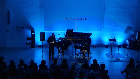 Bühne mit einem Konzertflügel in blaues Licht getaucht © NDR 
