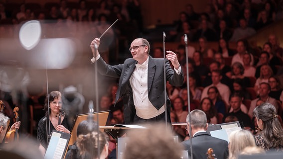 Die NDR Radiophilharmonie mit Dirigent Andrew Manze, im Hintergrund Publikum © NDR Foto: Micha Neugebauer