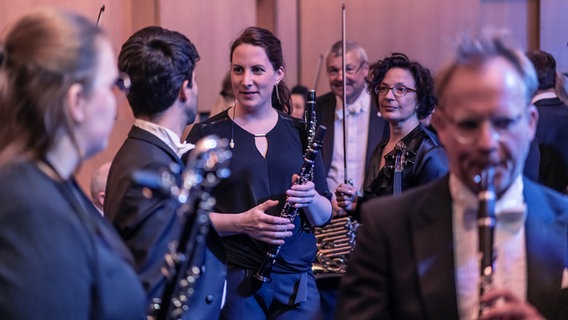 Musiker*innen der NDR Radiophilharmonie unterhalten sich hinter der Bühne © NDR Foto: Micha Neugebauer