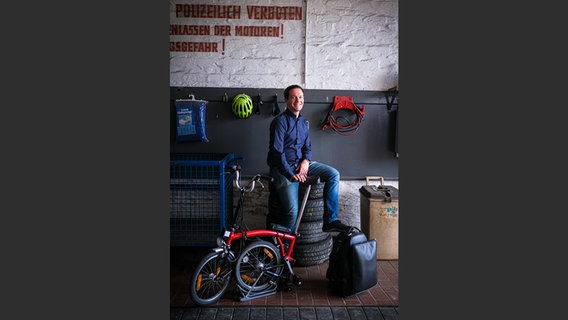 Ivo Dudler mit Fahrrad und Horntasche in einer Werkstatt © NDR Foto: François Lefèvre