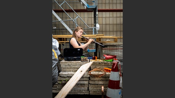 Johanna Stier mit Oboe auf einer Baustelle, im Vordergrund Werkzeug © NDR Foto: François Lefèvre