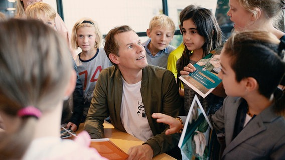 Moderator Malte Arkona wird von Kindern umringt. © NDR / Micha Neugebauer Foto: Micha Neugebauer