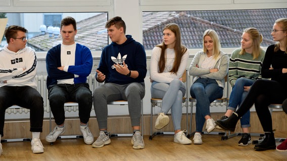 Ein Schüler spricht. Seine Mitschüler hören ihm zu. © NDR Foto: Sophie Brunner