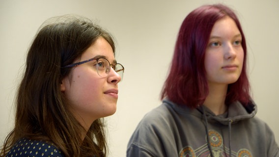 Zwei Schülerinnen hören interessiert zu. © NDR Foto: Sophie Brunner