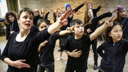 Eine Frau und mehrere Kinder heben den linken Arm und schauen nach links. © NDR Sinfonieorchester Foto: Marcus Krüger