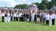 Gruppenbild des Vokalensembles auf einer Wiese  