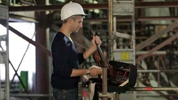 Auf der Baustelle der Elbphilharmonie: Boris Bachmann (mit weißem Helm) packt seine Geige aus © NDR 
