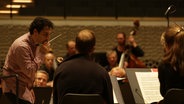 Screenshot: Andrés Orozco-Estrada dirigiert eine Probe mit dem NDR Elbphilharmonie Orchester in der Elbphilharmonie Hamburg © NDR Foto: Screenshot