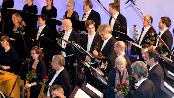 Jubiläumskonzert: Frau verteilt Rosen an die Sänger. © NDR Foto: Claudia Timmann