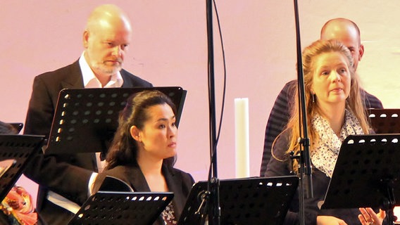 Probenszene: zwei Chorsängerinnen und zwei Chorsänger stehen hinter Notenpulten © NDR Chor Foto: Kristien Daled