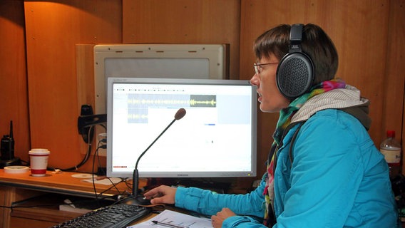 Tonmeisterin Karola Perry mit Kopfhörern spricht in ein Mikrofon © NDR Chor Foto: Kristien Daled