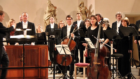 Konzertszene: Chorsänger und drei Instrumentalisten stehen für den Applaus © NDR Chor Foto: Barbara Rotering