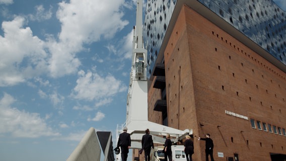 Screenshot: Fünf Mitglieder des NDR Vokalensembles steigen die Stufen zur Elbphilharmonie hinauf © NDR Foto: Screenshot