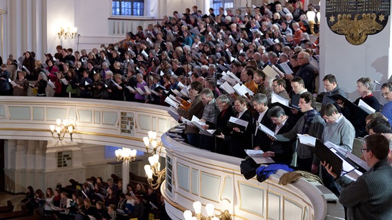 Im Konzert: Die Chorsänger und -sängerinnen im Kirchenschiff und auf der Empore sind mit großer Konzentration dabei. © NDR Foto: Dirk Uhlenbrock