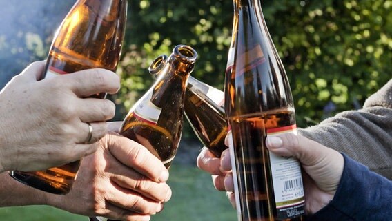 Mehrere Männer stoßen im Freien mit Bier an. © picture alliance Foto: Monique Wüstenhagen