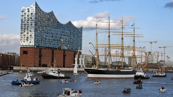 Begleitet von dutzenden Schiffen trifft die Viermastbark "Peking" (r.) in Hamburg ein. Begleitet von dutzenden Schiffen trifft die Viermastbark "Peking" (r.) in Hamburg ein. © picture alliance/rtn - radio tele nord Foto: frank bründel