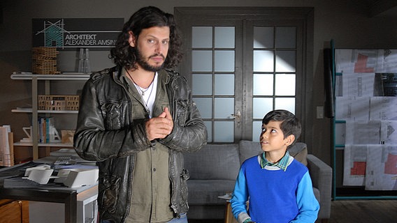 Luis (Emilio Sanmarino) steht neben seinem Vater Tiago (Manuel Cortez, links) in einem Büro. © NDR/Studio Hamburg Foto: Romano Ruhnau