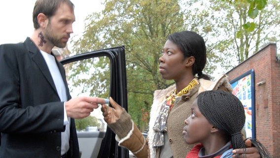 Schleuser (Alexander Wüst) mit Bisa (Dayan Kodua) und Acai (Amanda Adjei). © NDR/Romano Ruhnau 