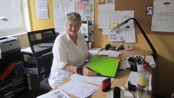 Produktionsassistentin Annelie Hamann sitzt am Schreibtisch mit Unterlagen. © NDR Foto: Ulrike Ziesemer