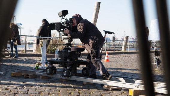 Der Kameramann fährt die Kamera auf Schienen. © NDR Foto: Claudia Timmann