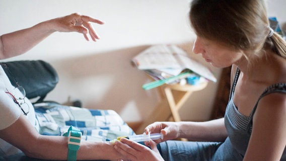 Eine ambulante Pflegekraft verabreicht einer Seniorin eine Spritze. © picture alliance / BSIP | AMELIE-BENOIST Foto: AMELIE-BENOIST