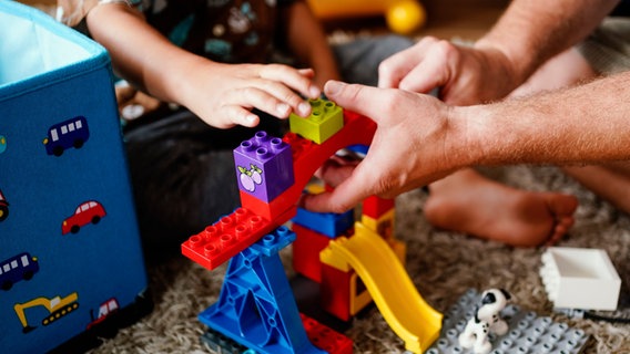 Das Bild zeigt die Händes eines Kindes und eines Mannes beim spielen mit Duplo-Bausteinen. © picture-alliance/dpa-Bildfunk Foto: Uwe Anspach