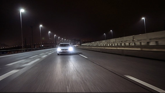 Ein Auto der Marke VW fährt nachts auf einer Schnellstraße. © Lucas Stratmann und Willem Konrad 
