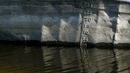 Auf dem Rumpf eines mutmaßlich mit Schotter beladenen Lastkahns, der im Dezember 2020 in der ukrainischen Region Saporischschja sank, sind Wasserlinienmarkierungen zu sehen, nachdem das Wasser zurückgegangen ist. © Photoshot 