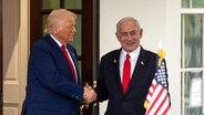 US-Präsident Donald Trump, links, schüttelt die Hand von Israels Ministerpräsident Benjamin Netanjahu aks sie aus dem Westflügel des Weißen Hauses in Washington kommen.
Service © picture alliance/dpa/AP | Mark Schiefelbein Foto:  Mark Schiefelbein