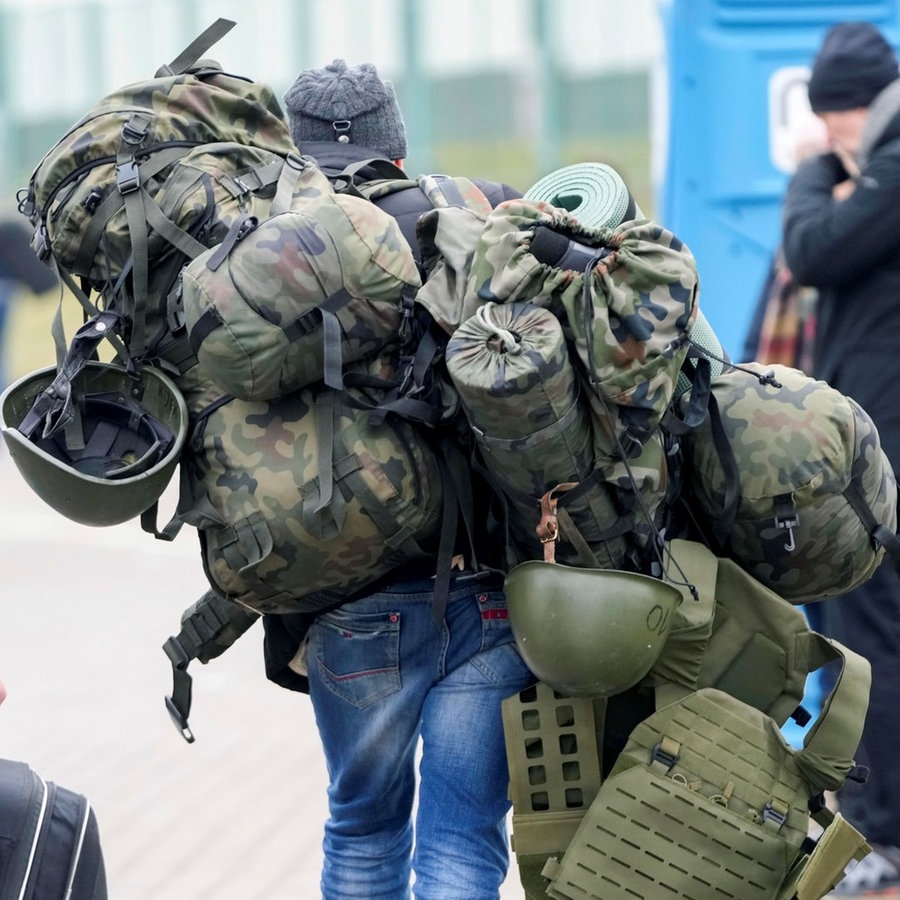 Ein Mann, der zuvor aus der Ukraine geflohen war, trägt am Grenzübergang in Medyka eine Kampfausrüstung, um in der Ukraine zu kämpfen. © picture alliance/dpa/AP | Markus Schreiber Foto: Markus Schreiber
