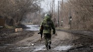 Ein Soldat läuft alleine die Straße entlang. © picture alliance/dpa/TASS | Stanislav Krasilnikov Foto: Stanislav Krasilnikov
