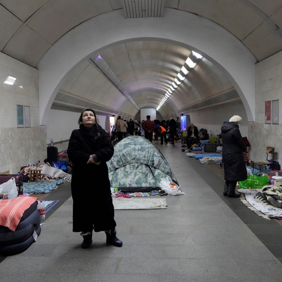 Eine Frau steht in einem U-Bahn-Tunnel und sucht mit anderen Menschen Schutz vor Luftangriffen © picture alliance/dpa/AP | Efrem Lukatsky Foto: Efrem Lukatsky