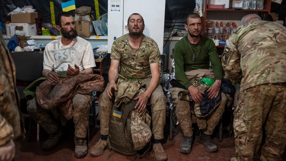 Ukrainische Soldaten sitzen in einem medizinischen Versorgungspunkt. © picture alliance/dpa/AP | Iryna Rybakova 