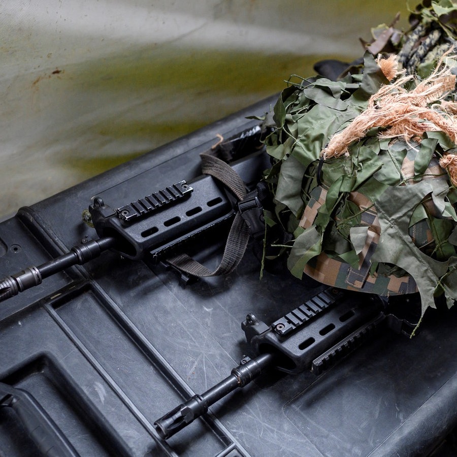 Zwei Maschinengewehre und zwei Helme liegen auf einer Box. © dpa Foto: Daniel Vogl