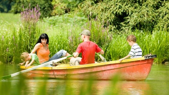 Eine Familie in einem Ruderboot auf einem See. © Colourbox Foto: Kzenon