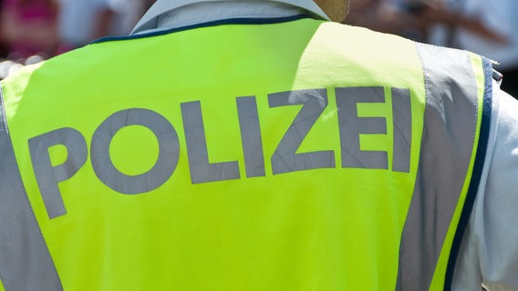 Ein Polizist von hinten mit einer Leuchtweste © Colourbox 