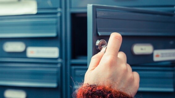 Eine Hand öffnet einen leeren Briefkasten. © fotolia.com Foto: LoloStock