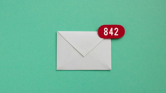 Ein weißer Briefumschlag liegt auf einer grünen Flache, die Zahl 842 ist auf einem roten Sticker aufgedruckt. © Photocase Foto: Marie Maerz