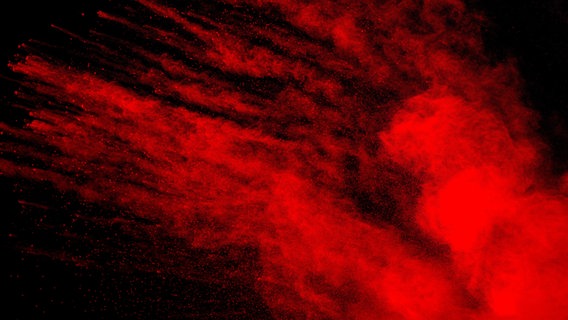 Rotes Pulver Explosion auf schwarzem Hintergrund. © picture alliance / Zoonar | Pattadis Walarput Foto: Pattadis Walarput