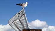 Eine Möwe sitzt auf einem Strandkorb auf dem 2023 steht © photocase Foto: MacRein