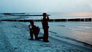 Zwei Matrosen der Grenzbrigade Küste bei einem Kontrollgang am Strand, aufgenommen im Juni 1978. © picture-alliance/ ZB 